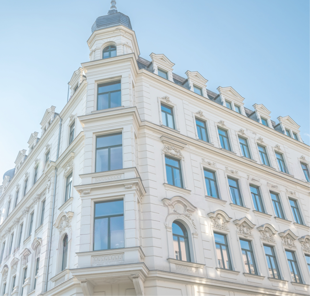 Stilvoller Altbau mit Erkern und hellem Himmel.
