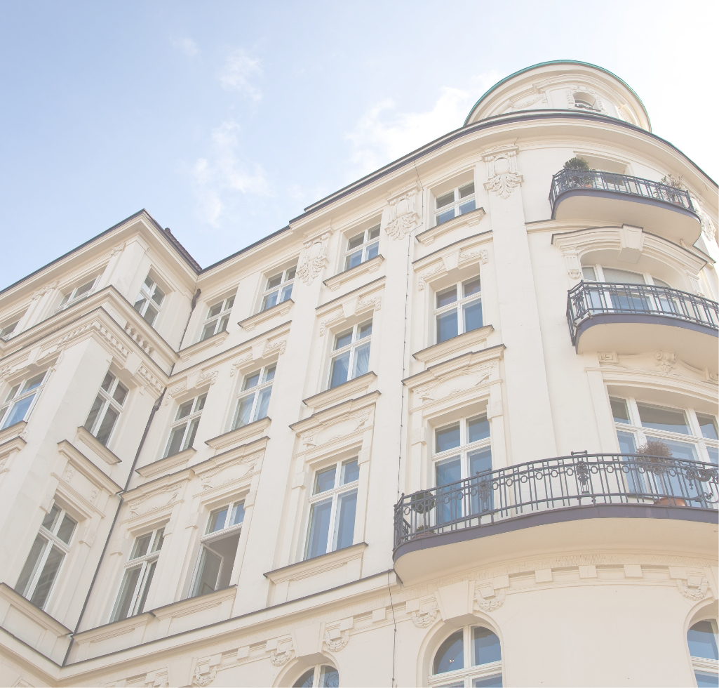 Elegant gestaltetes Eckgebäude mit runden Balkonen und Stuck.