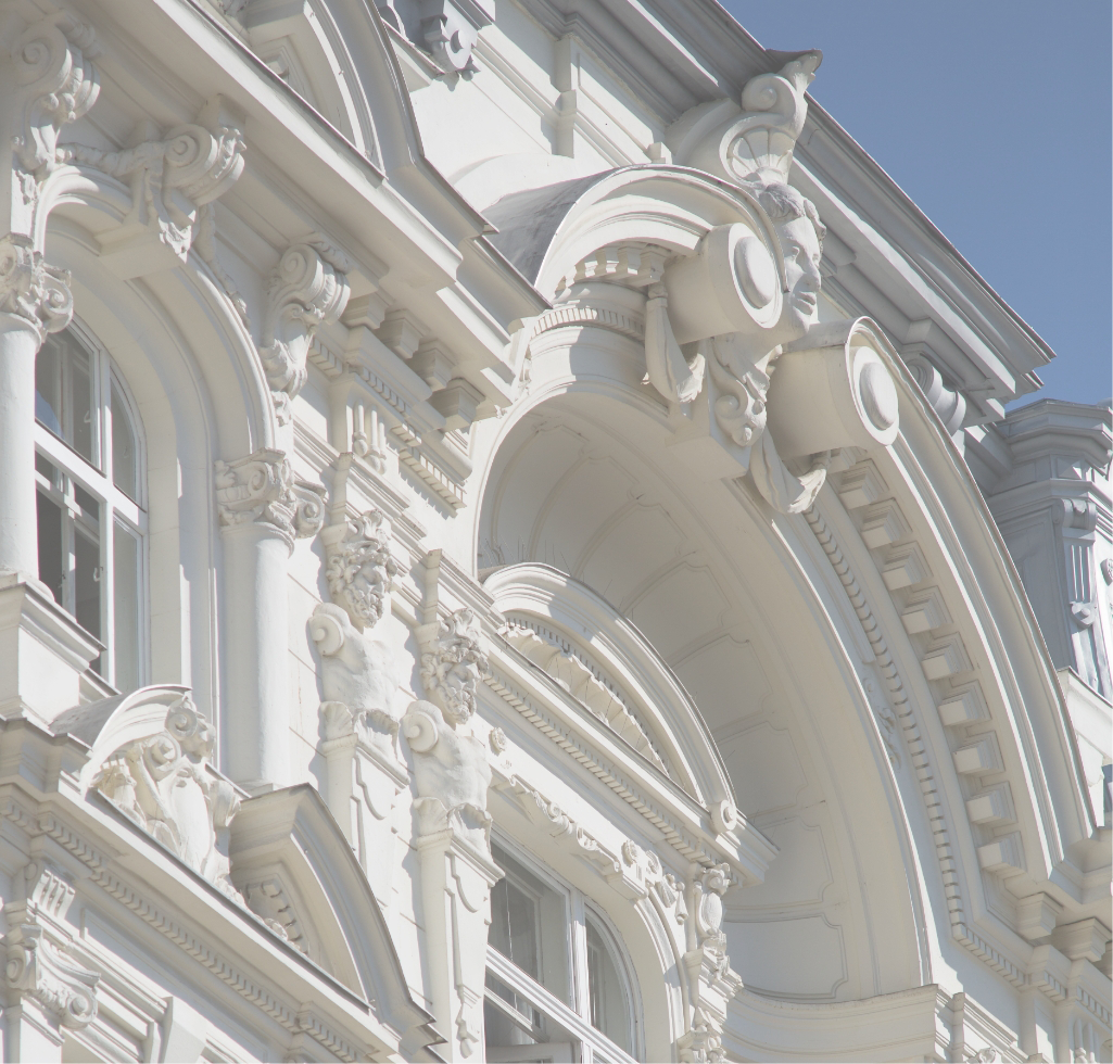 Nahe Aufnahme der kunstvoll verzierten Fassade eines Altbaus.